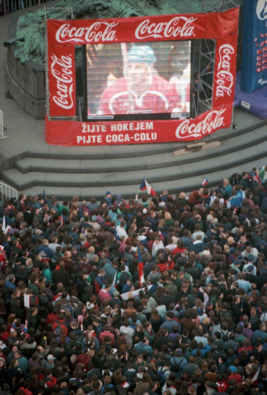 Přílet českých hokejistů, kteří vybojovali zlatou medaili na ZOH v japonském Naganu. Na snímku pohled na zaplněné Staroměstské náměstí s velkoplošnou obrazovka - reklama firmy Coca-Cola.